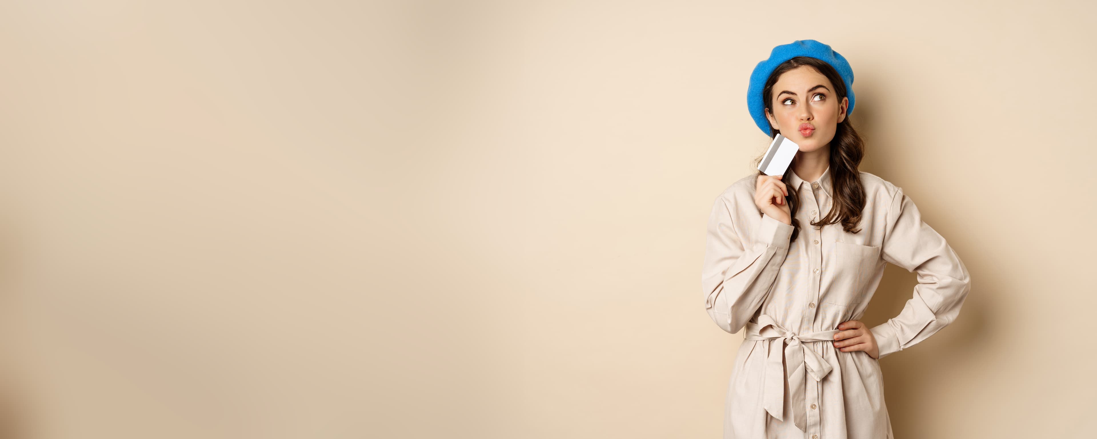 Five small potted plants displayed on beige stacked blocks, featuring a variety of green foliage in dark gray pots against a neutral background.